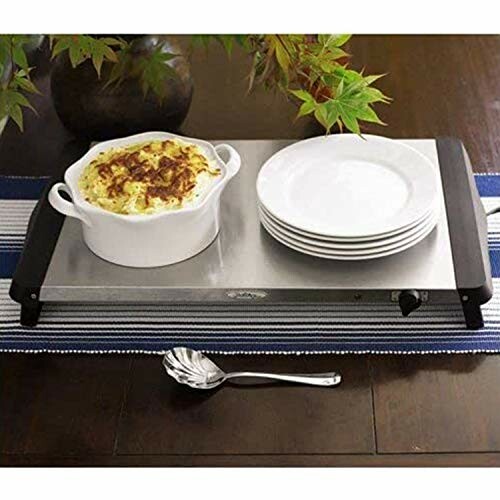 Buffet warmer with casserole dish and stacked plates on a table.