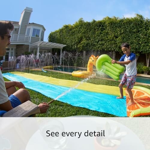Children playing on a colorful slip-n-slide in a backyard.
