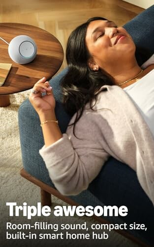 Woman relaxing on a couch with a smart speaker on a table.